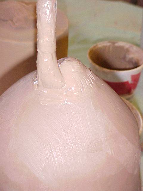 Applying slip to the jug to attach to spout